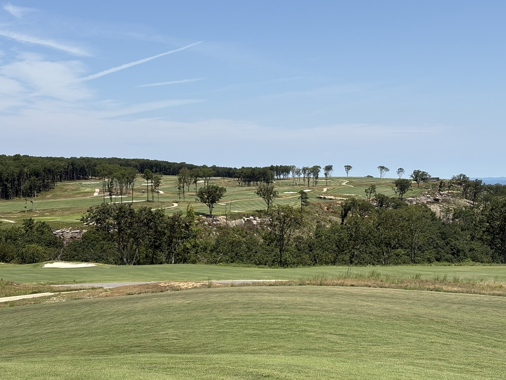 Craig Spiesman image showing a scenic golf course with rolling greens and tree-lined hills